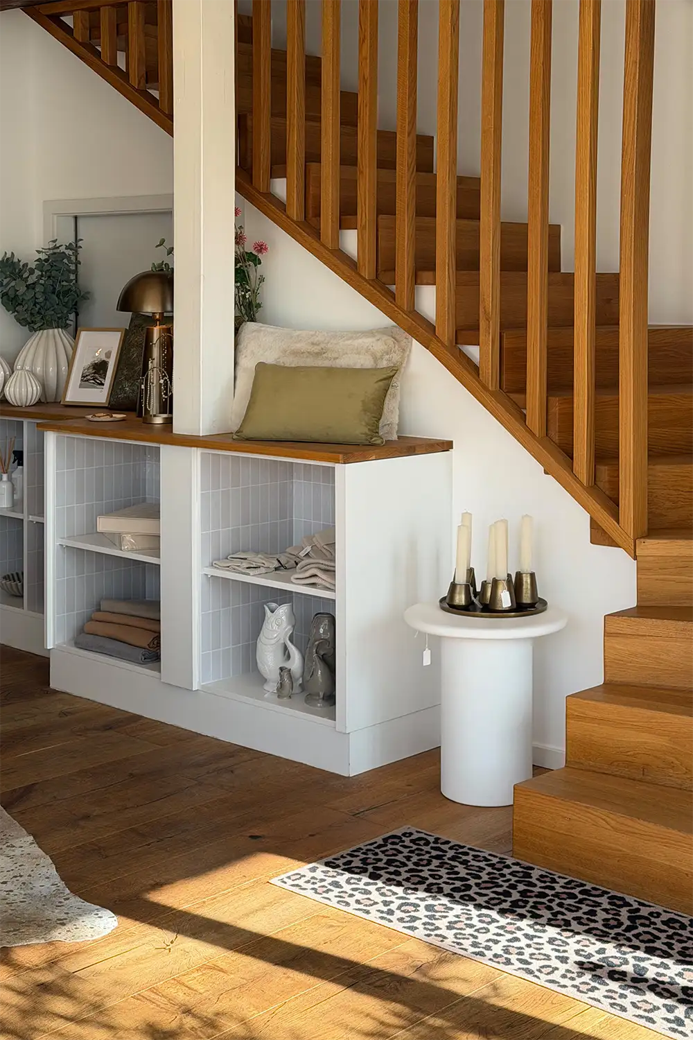 monas-store-huettenberg-wohndekoration-und-accessoires Wohnbereich mit Holztreppe, dekorierten Regalen und ausgewählten Wohnaccessoires.